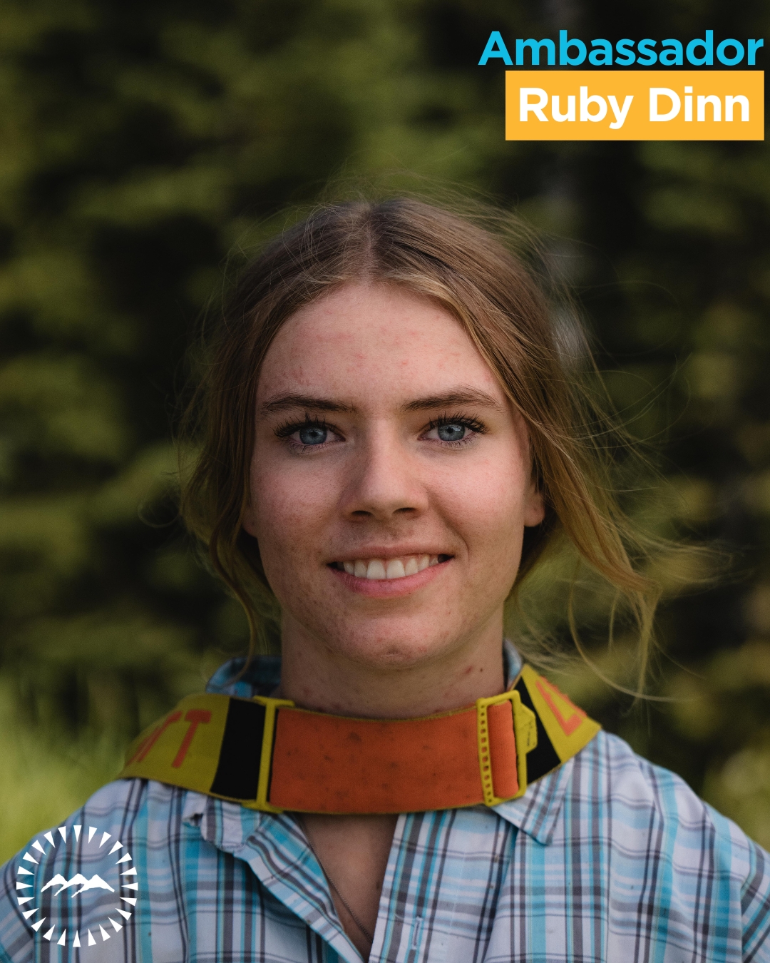 girl smiling at the camera with greenery in the background