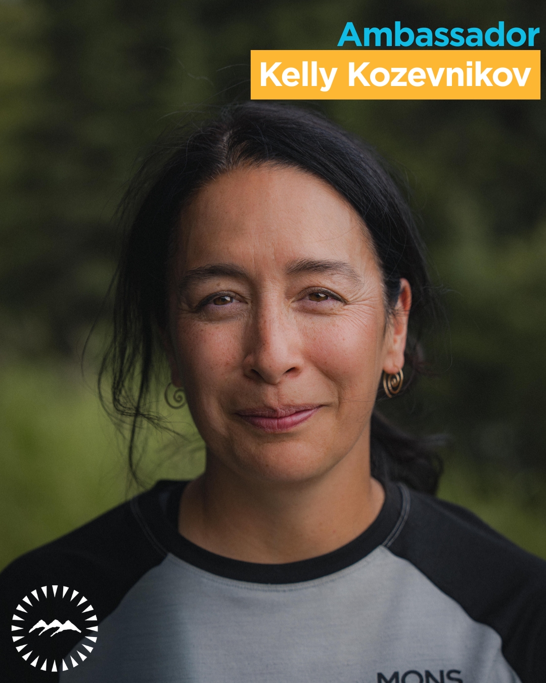 woman smiling at the cameras wqith greenery behind her