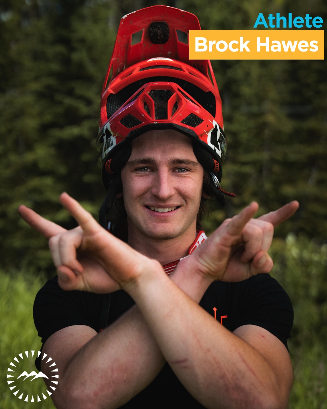 Male smiling at the camera with trees behind him