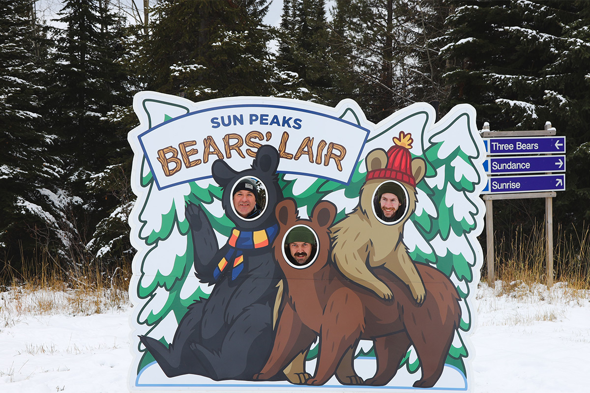 Three faces pop through new new Bear's Lair photo op sign with cutouts to pose as bears