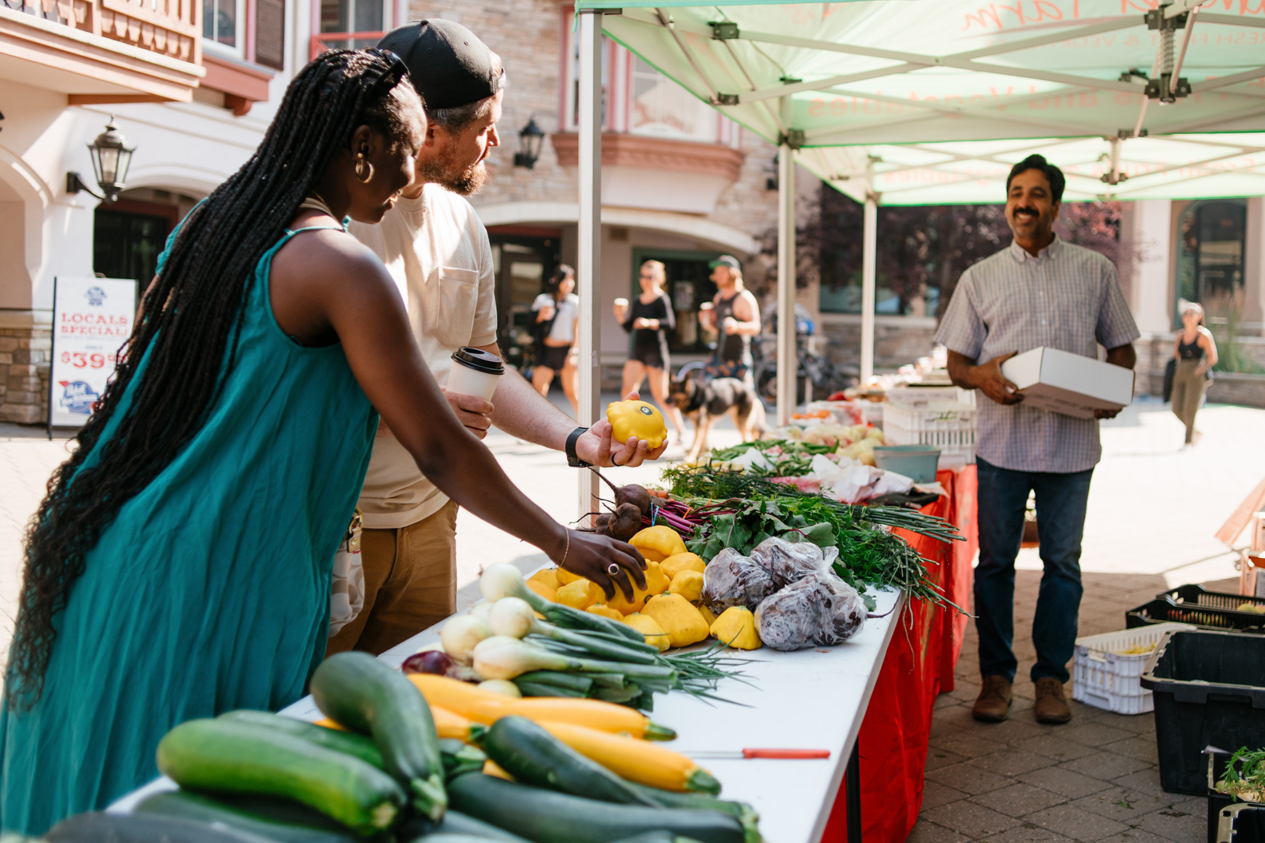 Couple selecting produce from vendor at sun peaks market day