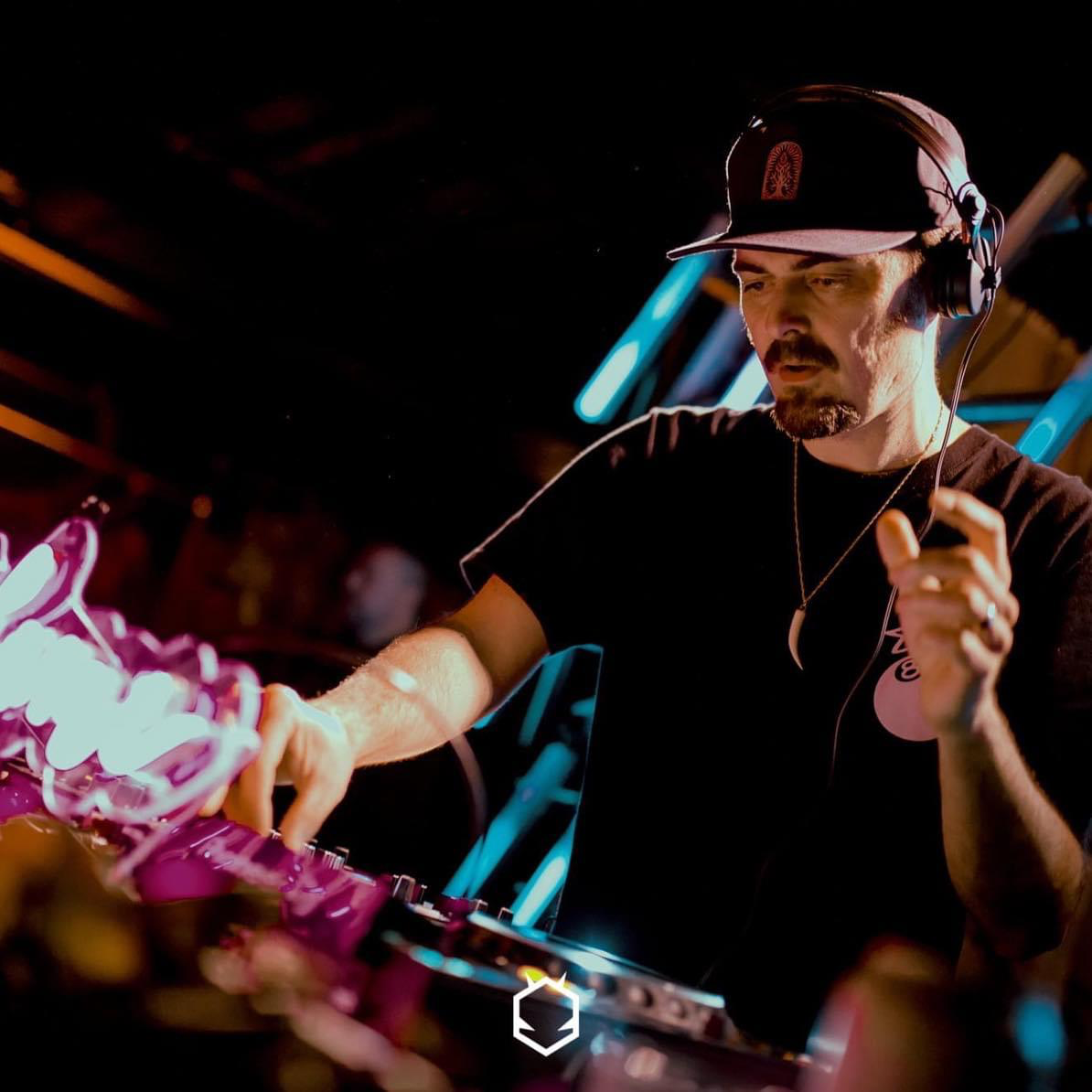 Jon Delerious DJing in dark background.