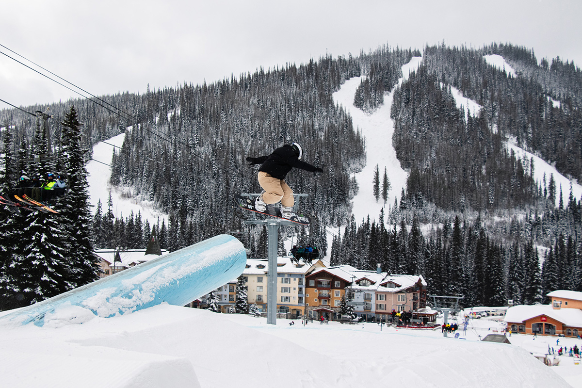 Snowboarder, Katie Brayer, launches off a blue canon in the terrain park towards the village. 