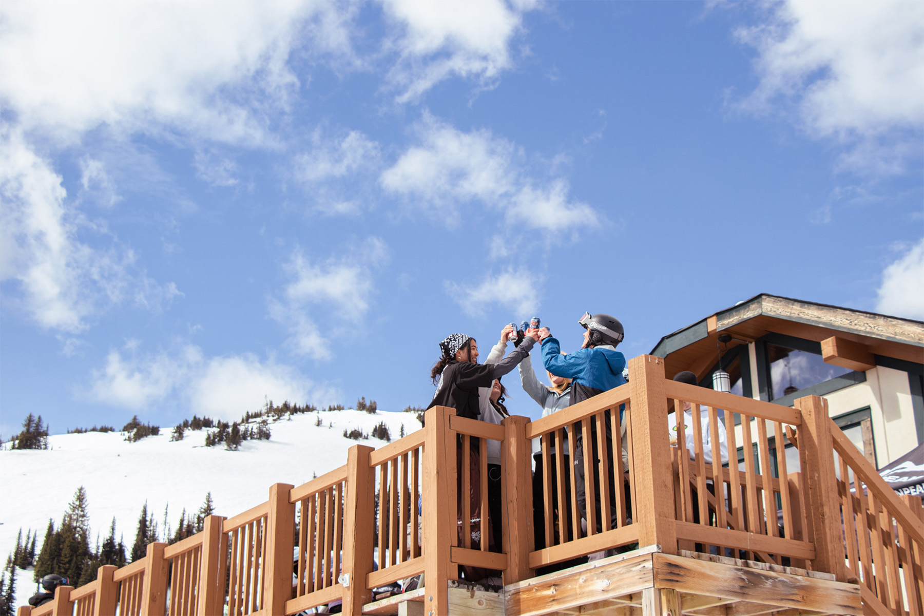 Friends toasting at Sunburst Lodge Patio on a bluebird ski day.