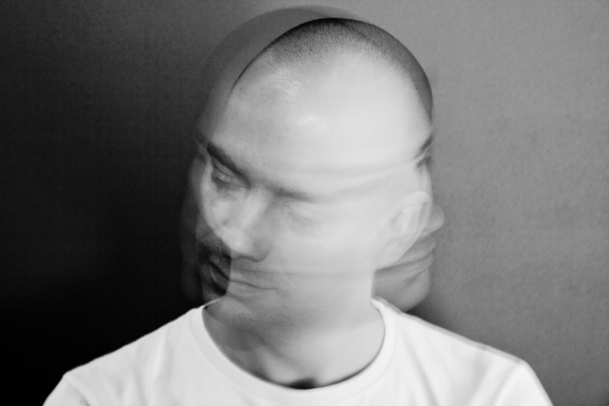 Man with blurred shaking head in black and white.