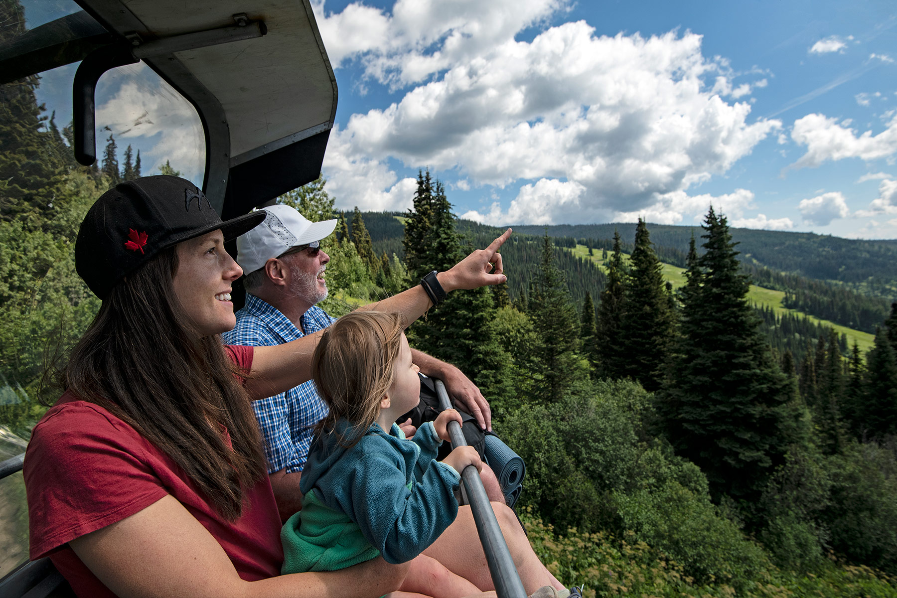 Mum, grandad, and daughter enjoying summer sightseeing on the Sunburst charlift.