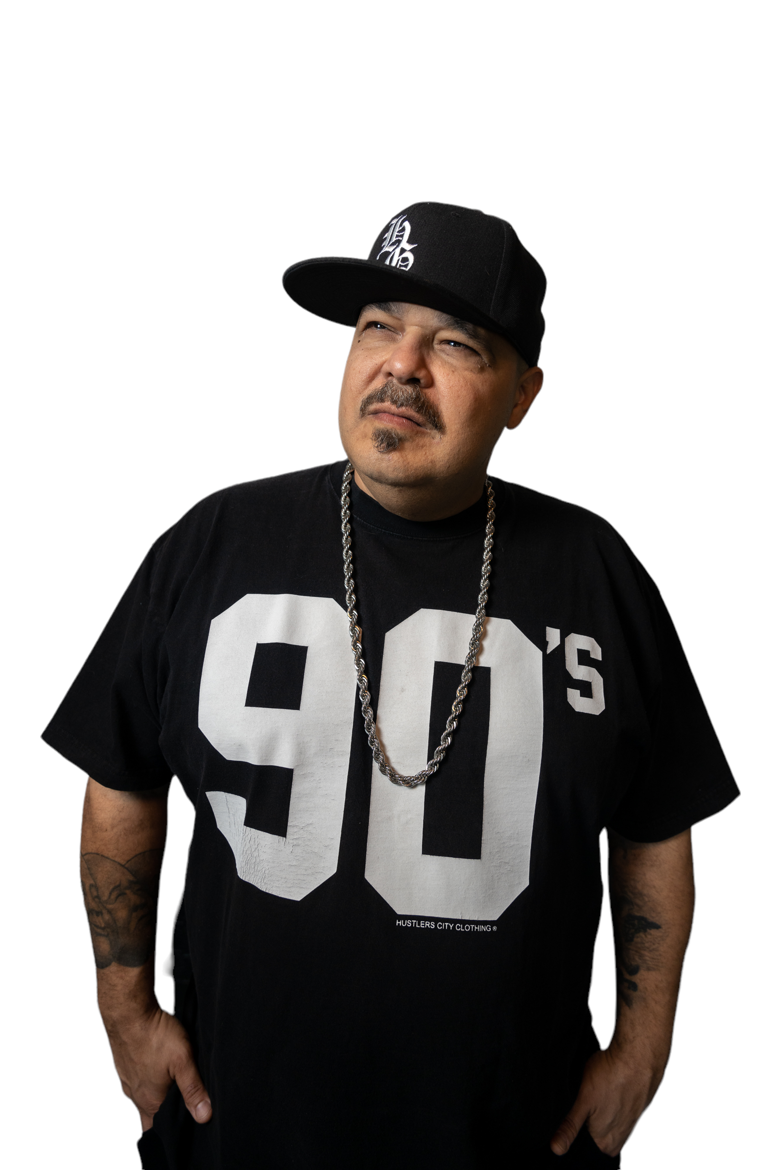DJ Sneak wearing a black jersey, silver chain, and black snapback.