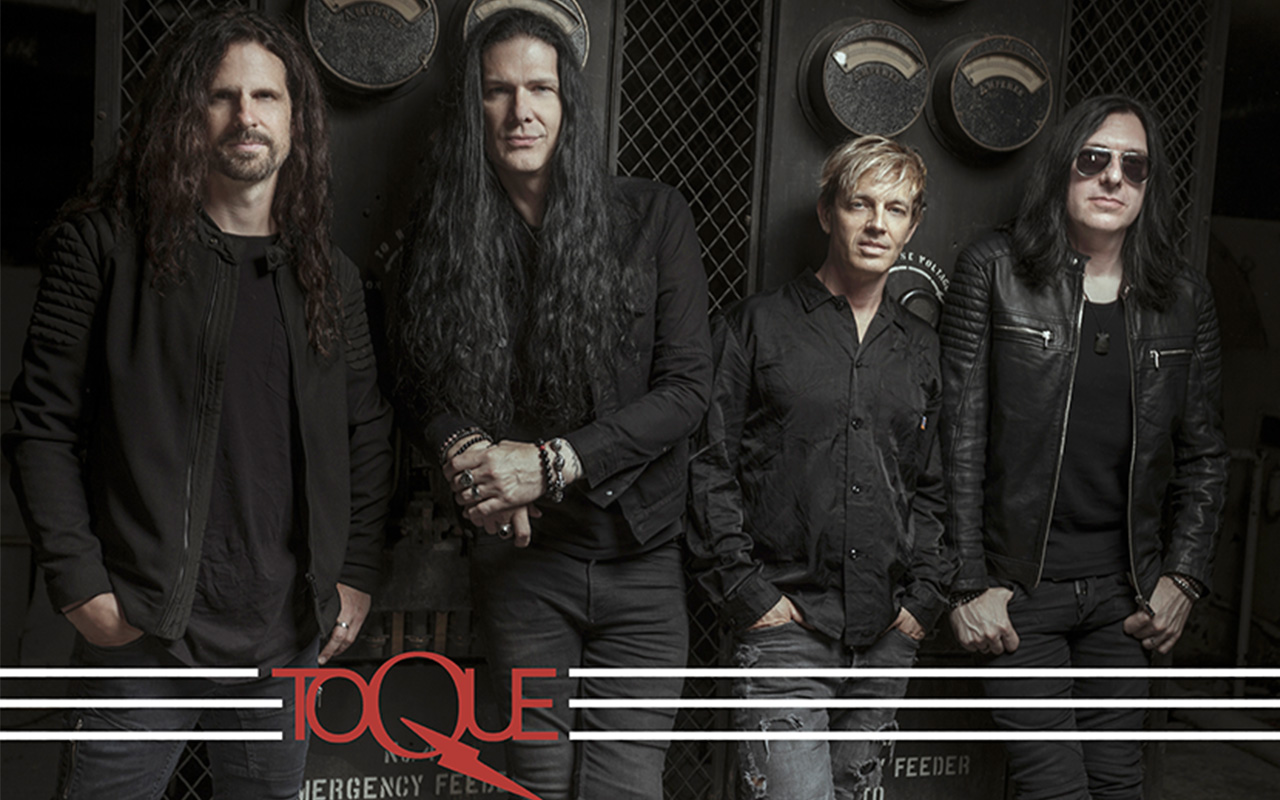 Four members of the band TOQUE dressed all in black backstage.