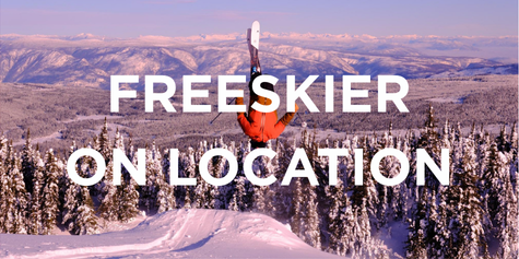 View of snowy Mountains with a skier doing a flip off a jump