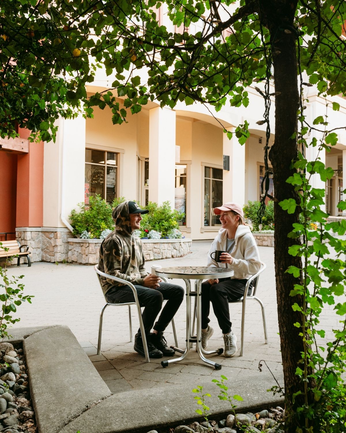 Two people sitting at a cafe table having coffee in the village.