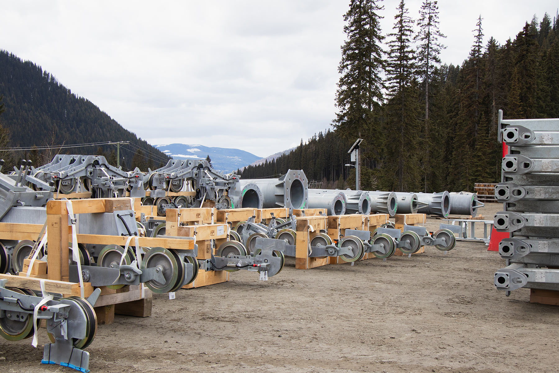 Lift towers and sheave assemblies for new West Bowl Express chairlift staged in parking lot.