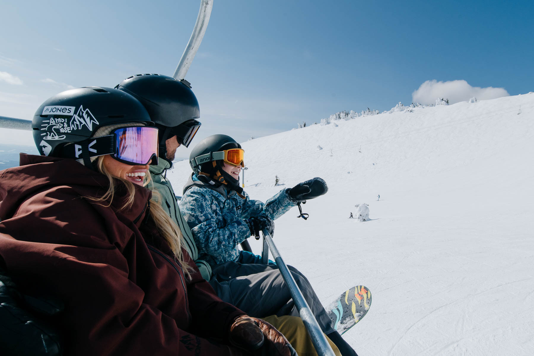 family riding chairlift in sun peaks