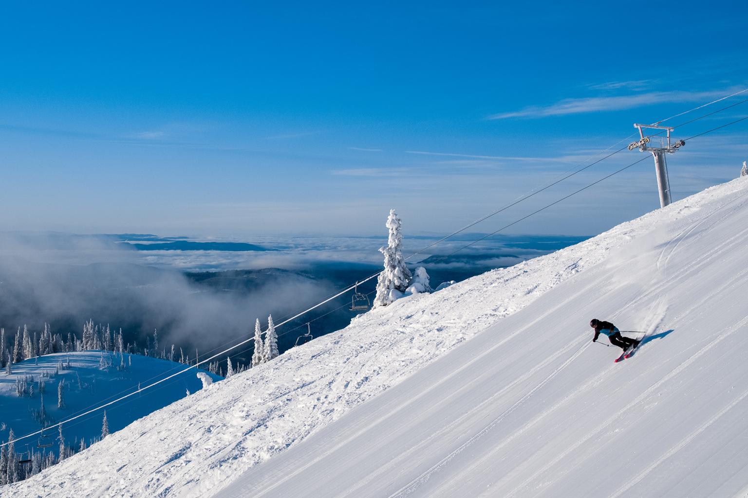 Alpine skiing in Sun Peaks with chairlift and blue sky