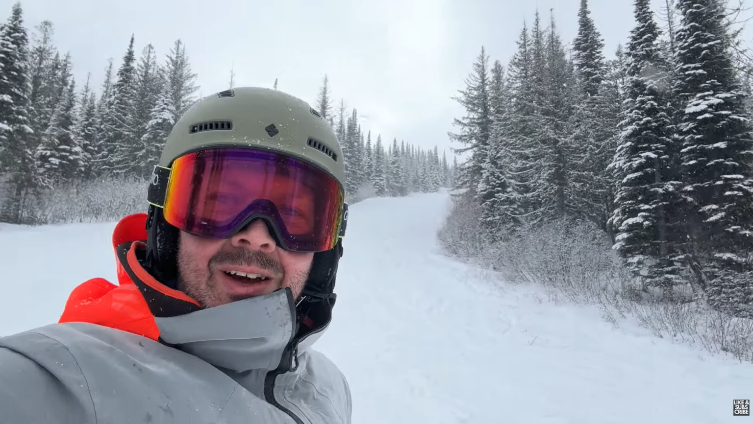 Uphill view of a ski run with the skier talking to the camera