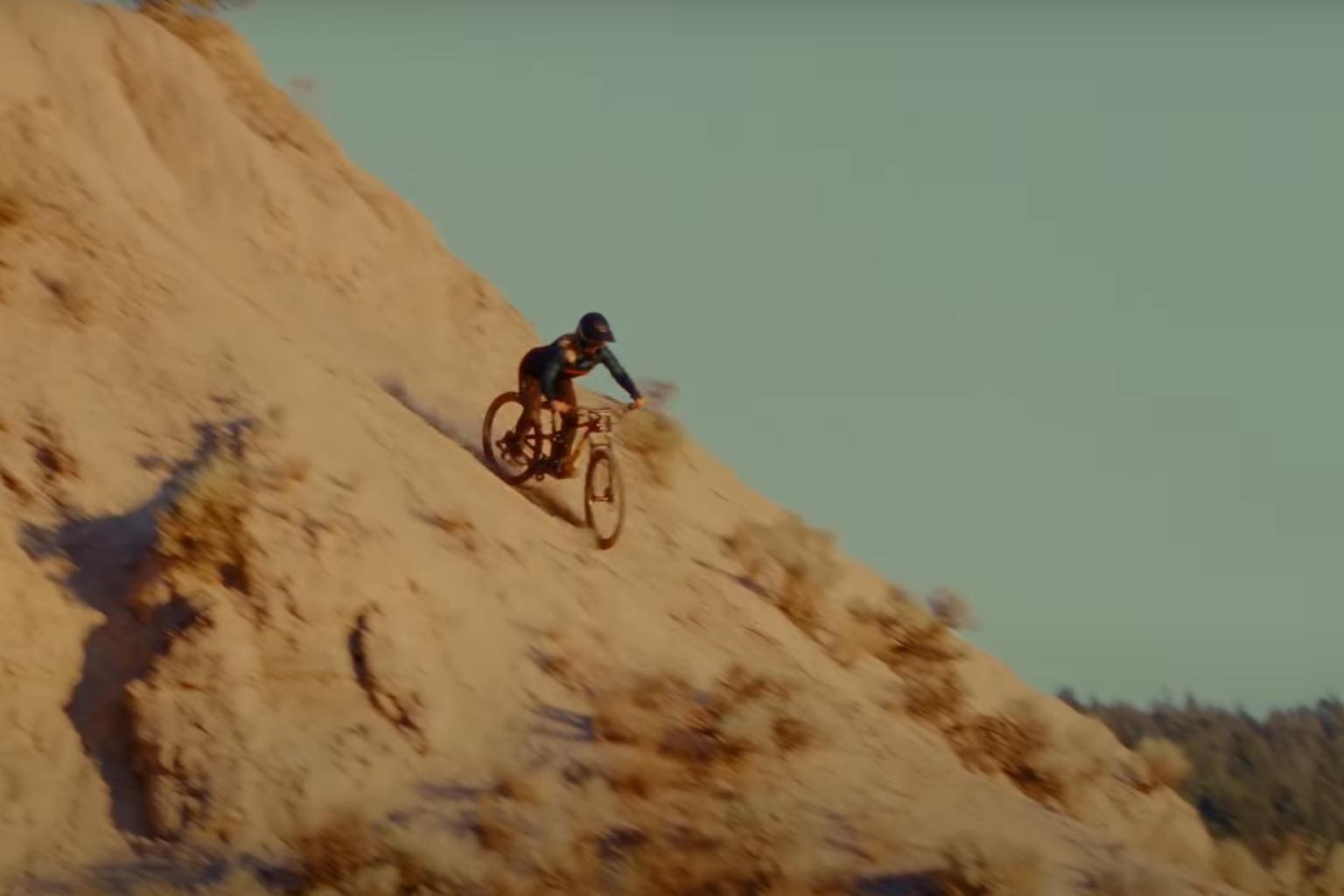 Female biker riding down a steep trail 