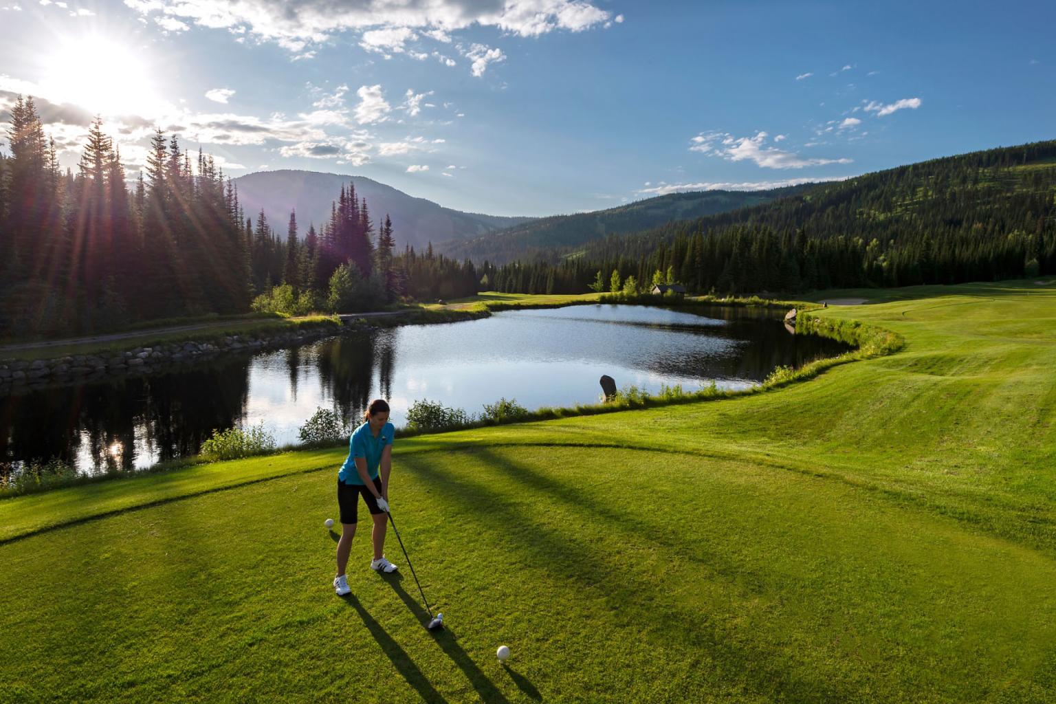 Woman teeing off on the sun peaks golf course 