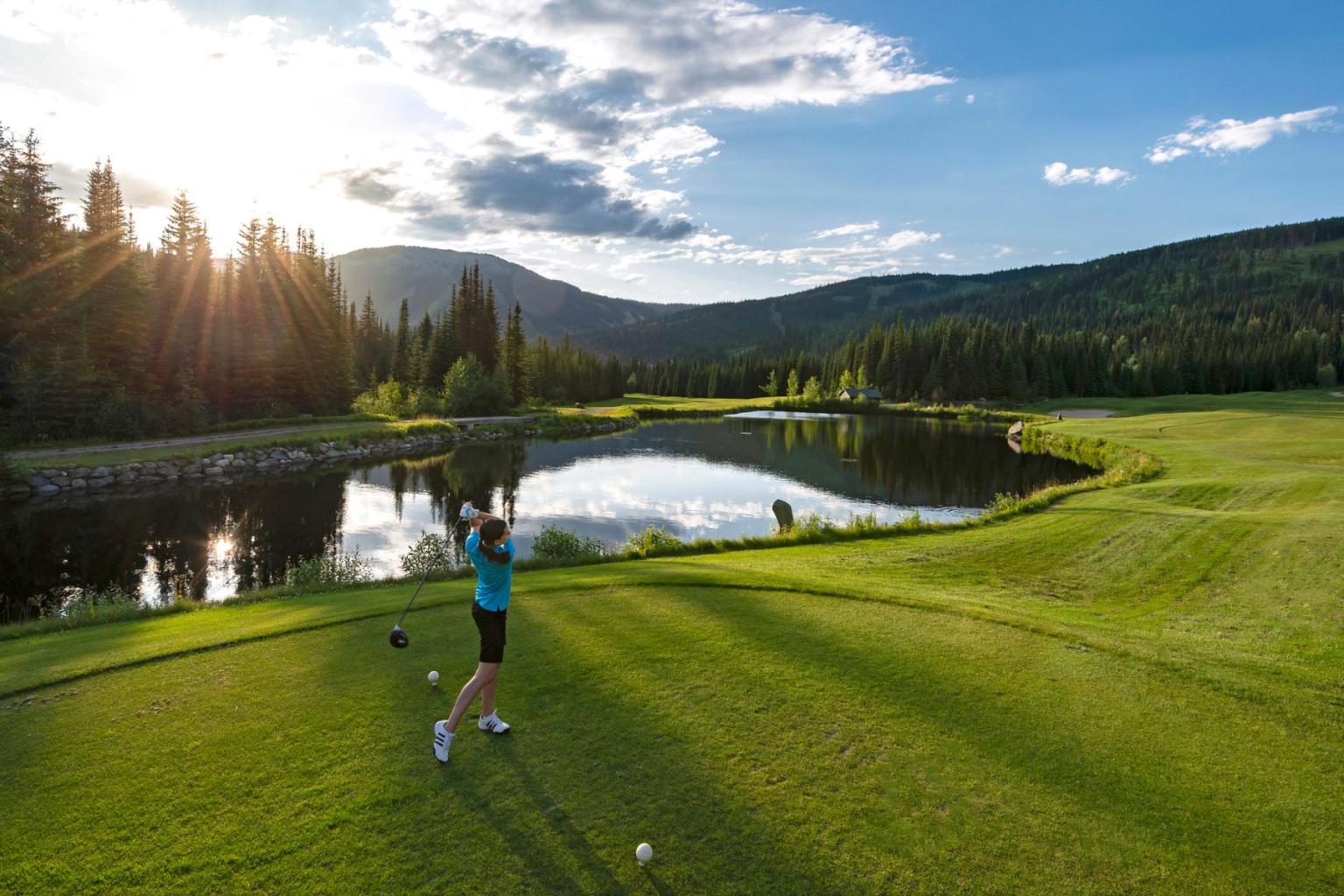 A lady golfing with mountain views in the background