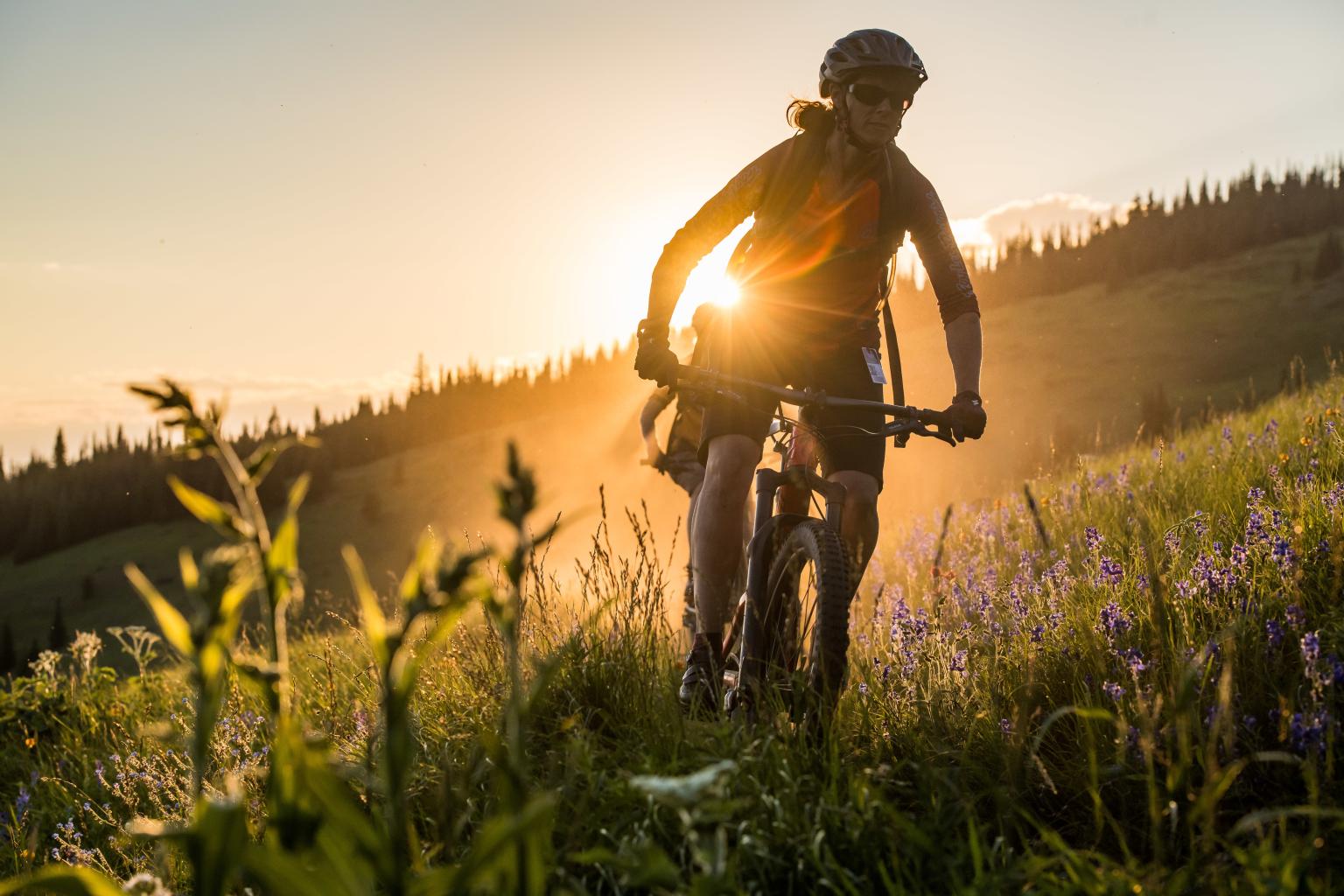 cross country biker on trail with sunset