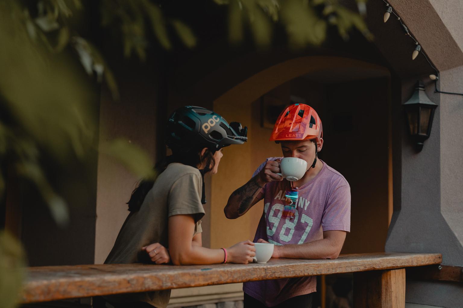 Couple drinking coffee in sun peaks village after bike ride