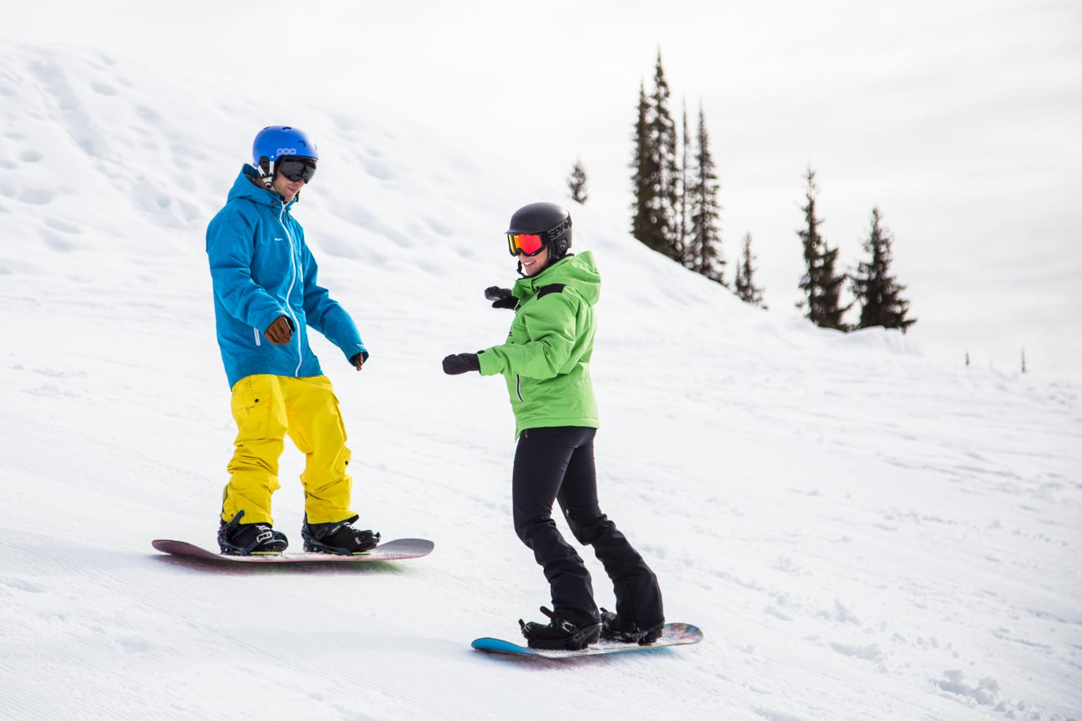 two snowboarders on slope during lesson