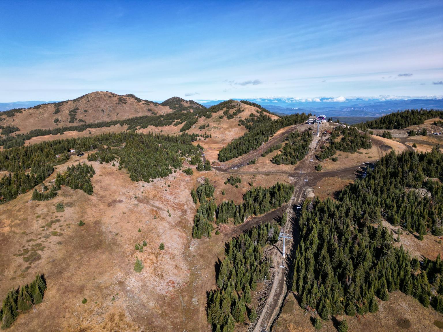 View of the top of west bowl with no snow and blue skies
