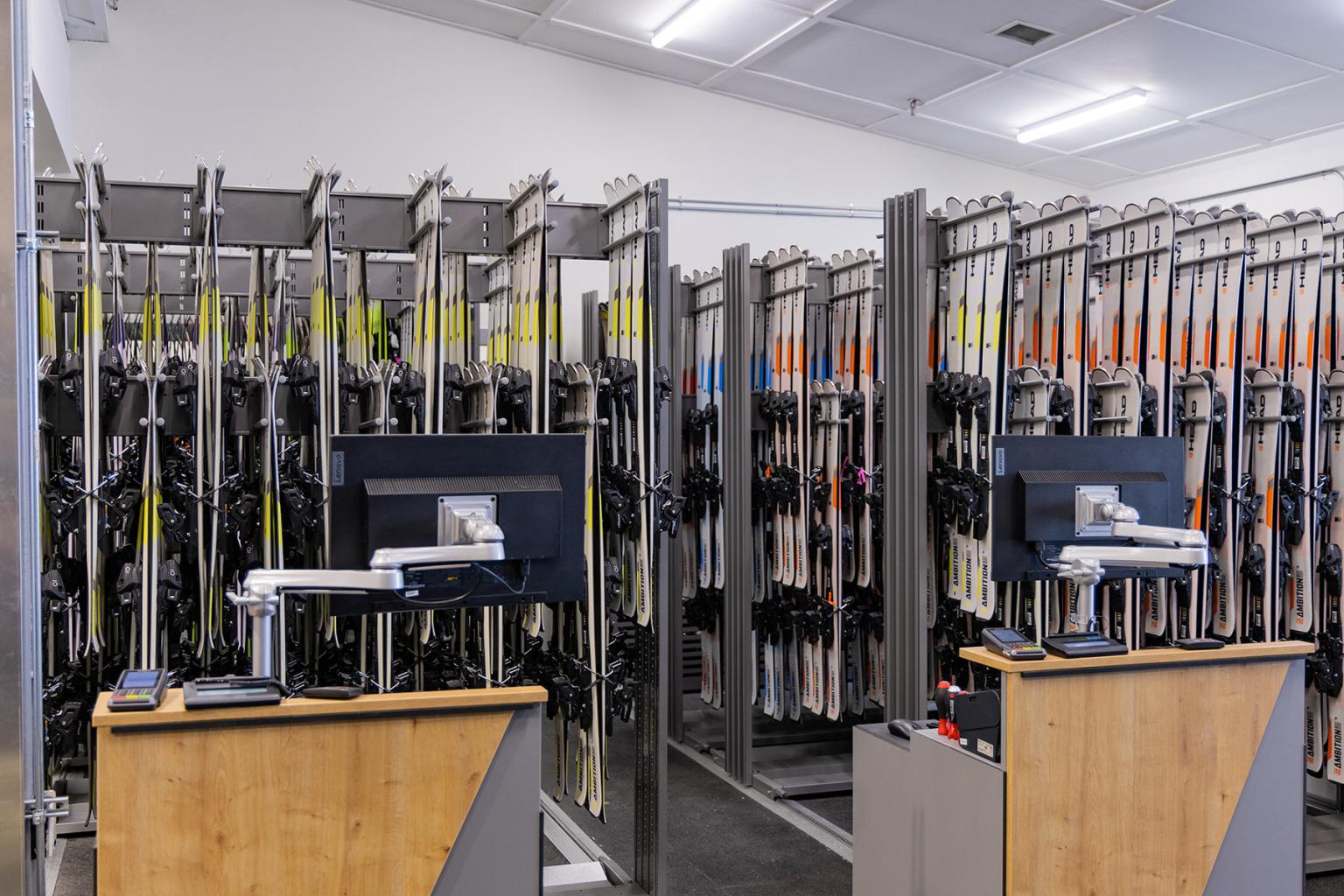 Rental skis hanging with two desks and computers
