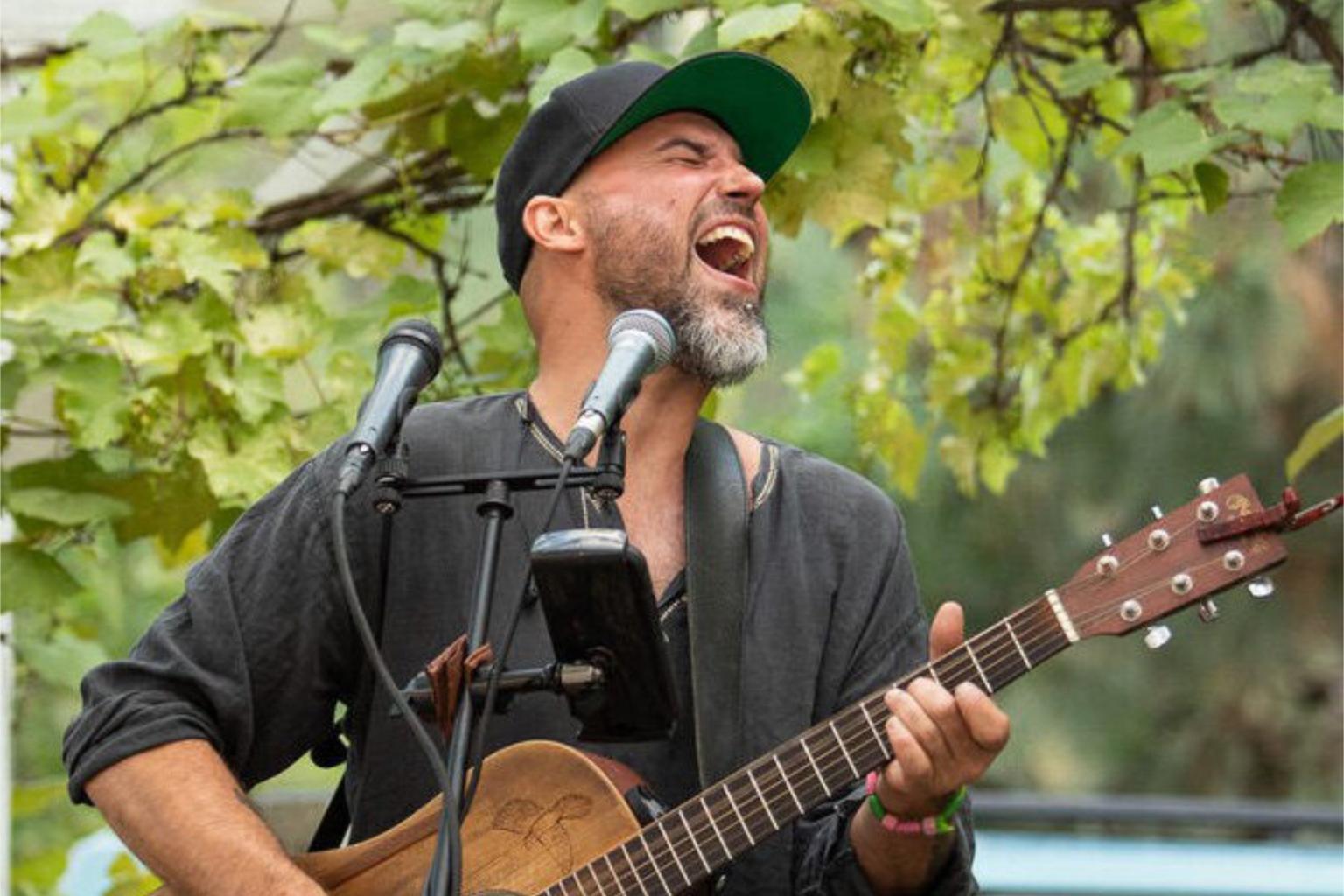 man singing and playing a guitar