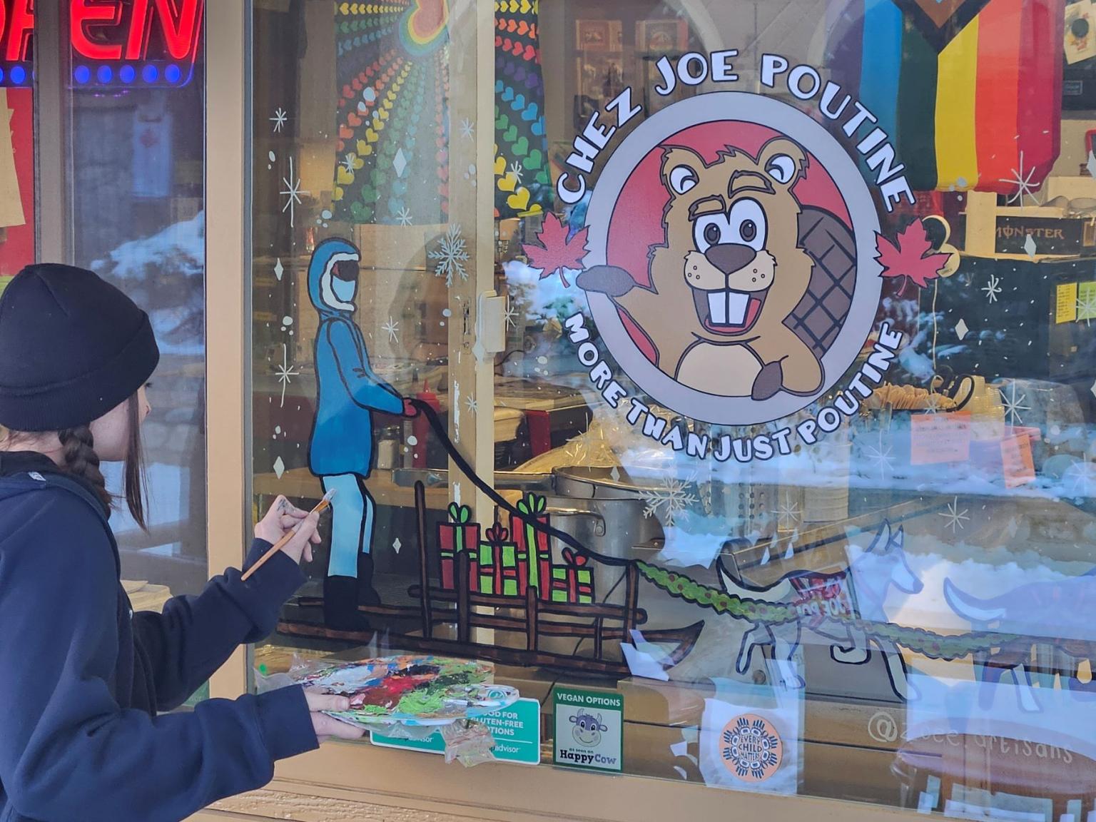 Artist Zoee Repar painting village windows