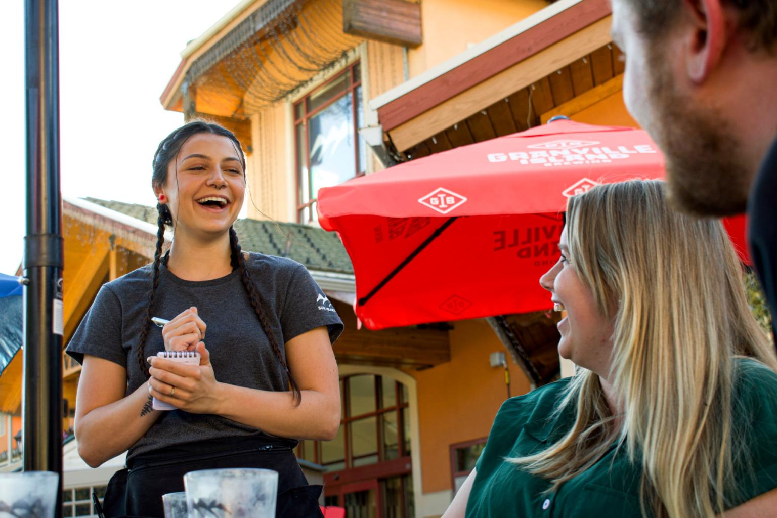 Server with guests laughing