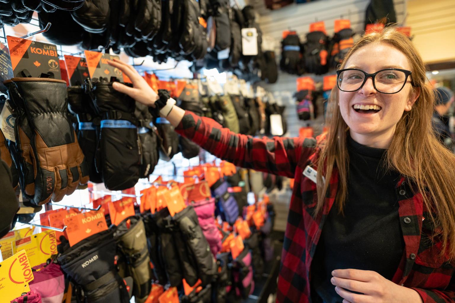 Staff member smiling and hanging gloves