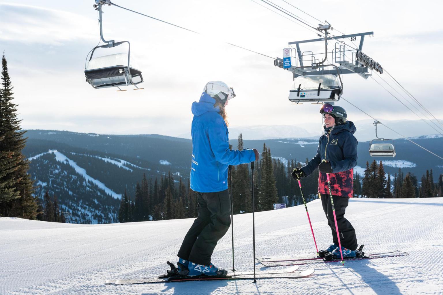 Ski school instructor gives a private lesson to an intermediate skiier under the Sunburst chairlift.