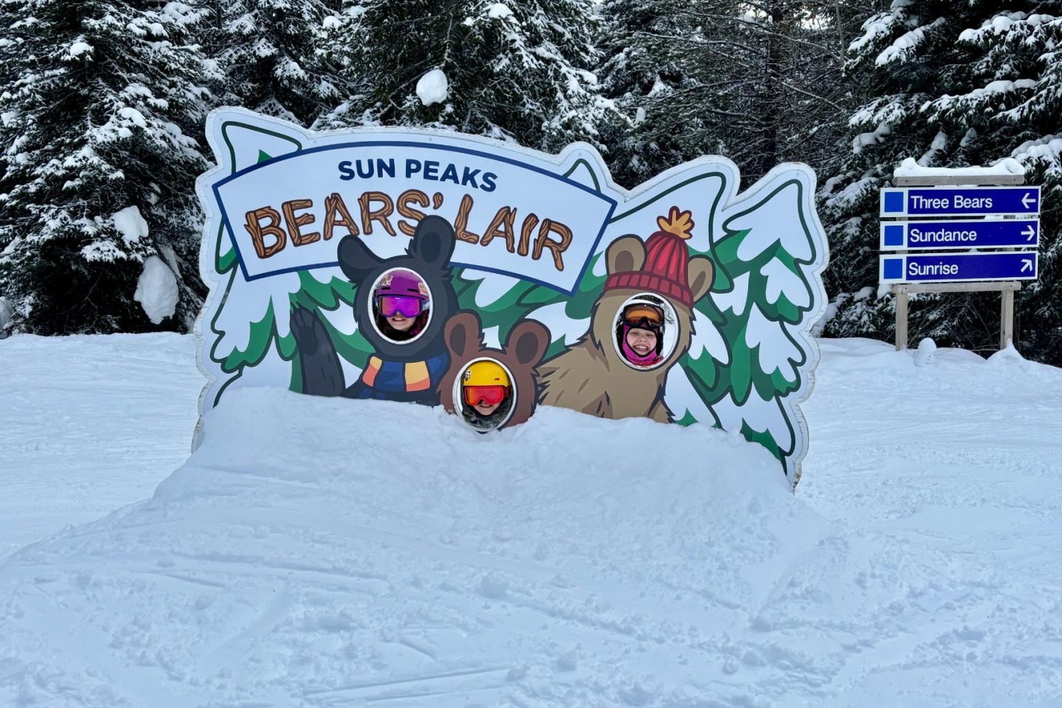 Snow-covered bear-themed photo stand with forest background.
