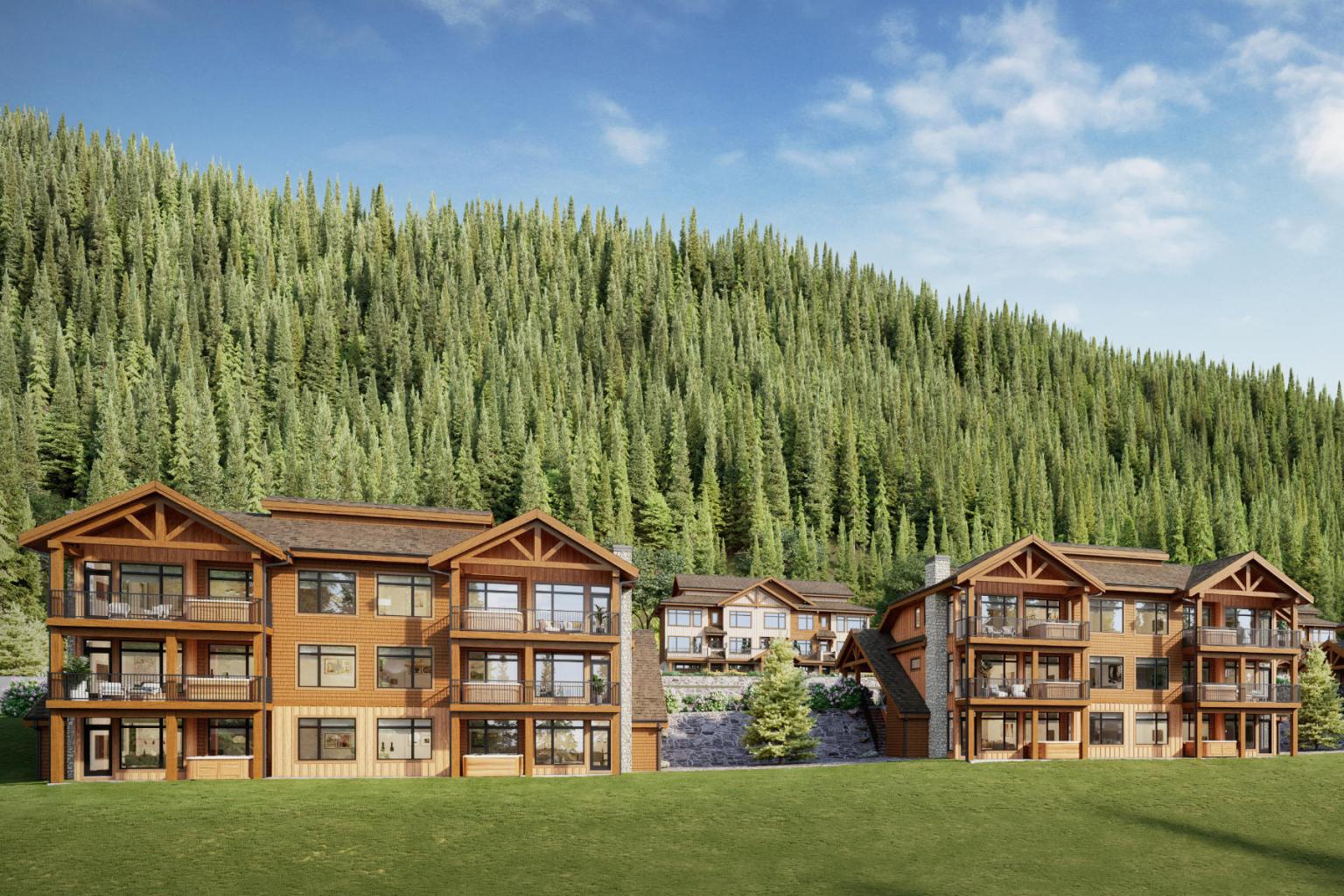Wooden lodges in a lush, forested mountain setting under a blue sky.