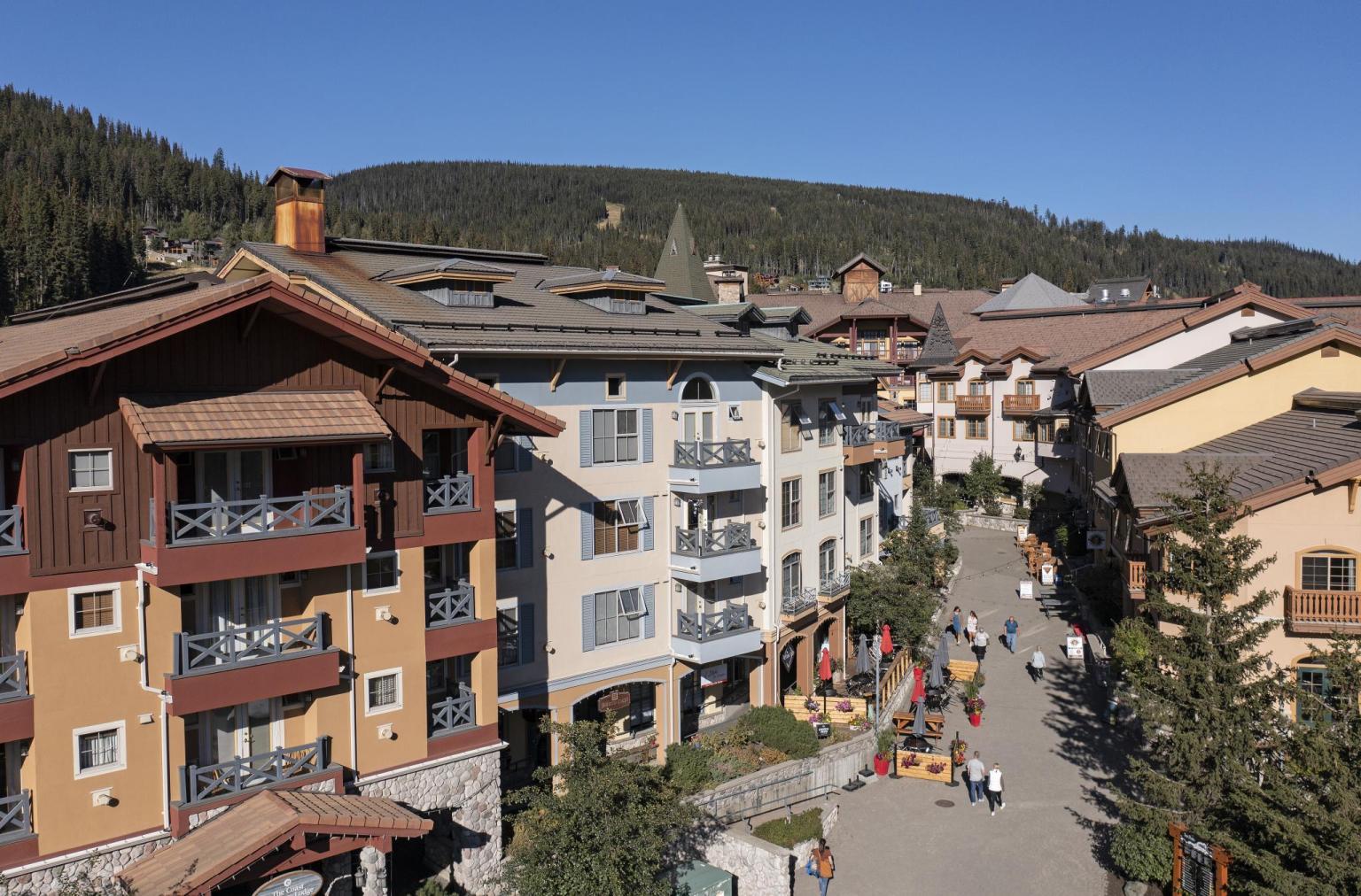 Alpine village street with colorful buildings under clear blue sky.