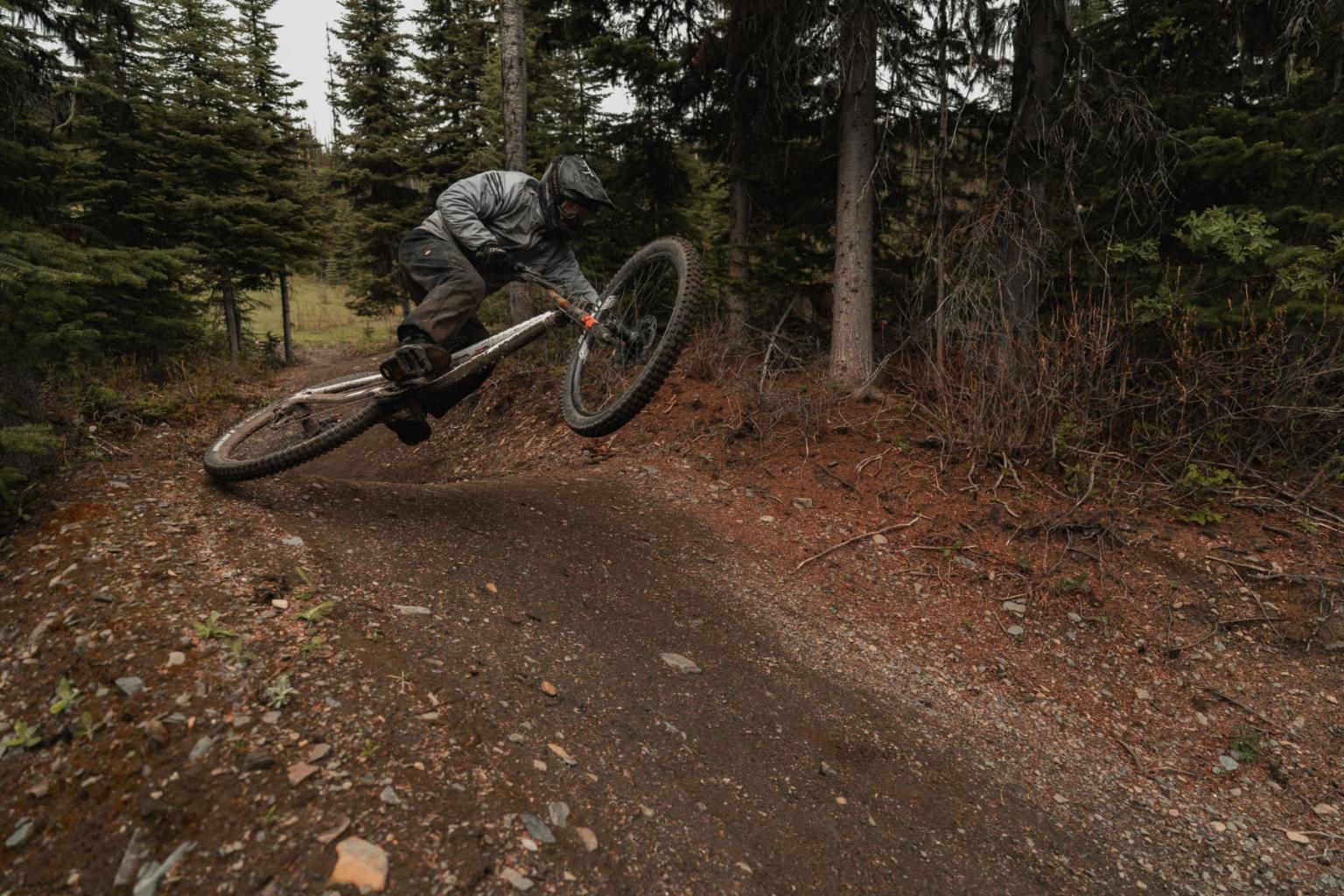 Mountain biker jumps on forest trail.