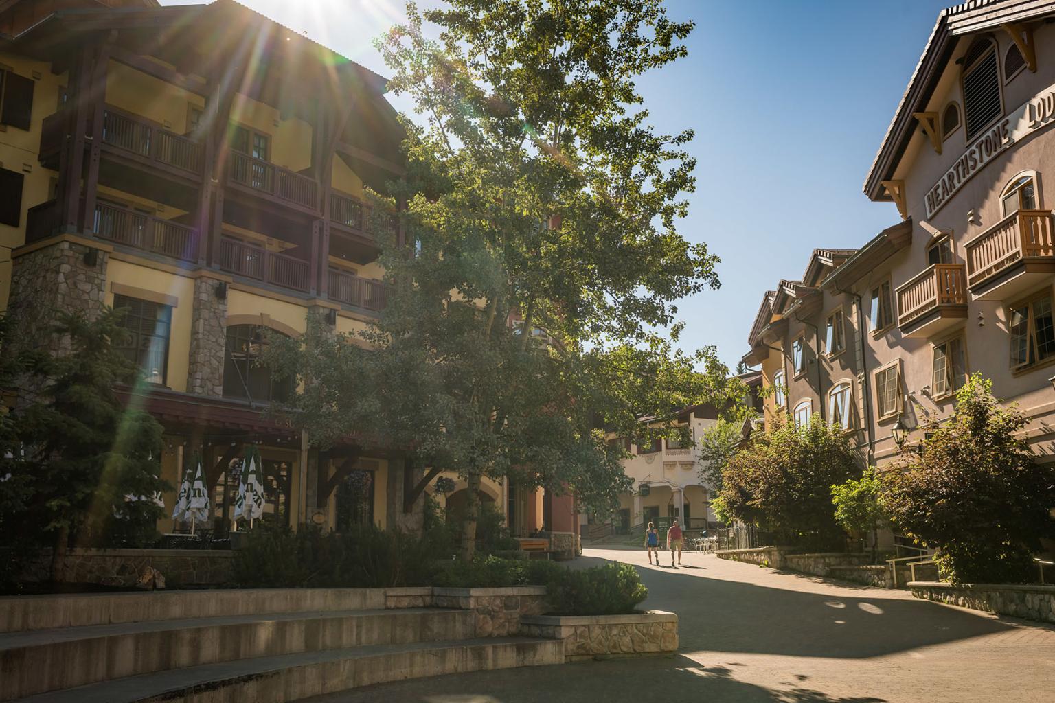 Sun flare behind Sun Peaks Grand Hotel entrance and nearly empty morning village street in Sun Peaks