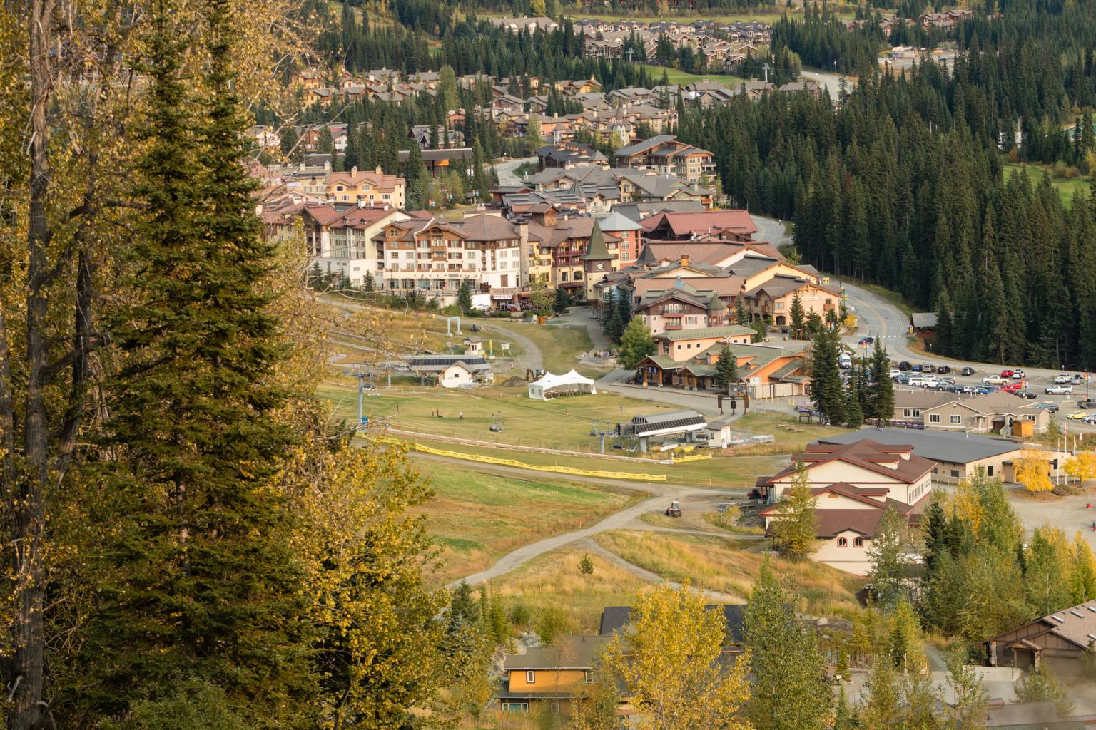 Small mountain village surrounded by trees and fall foliage.