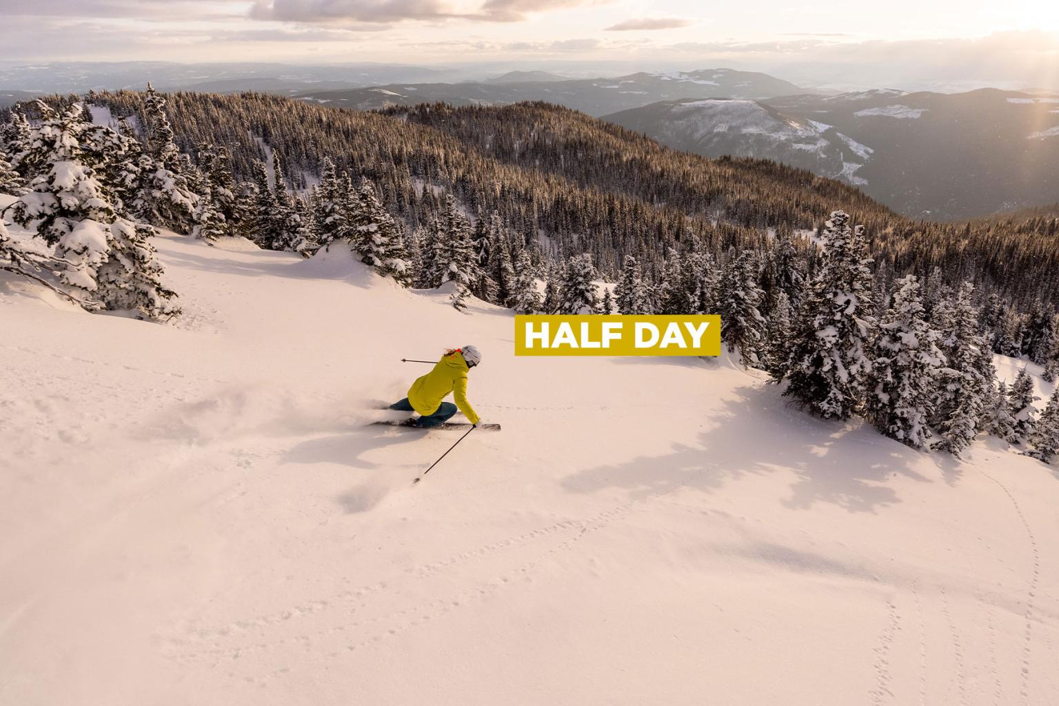 Skier in yellow jacket descends snowy mountain at sunset , with the words “Half Day” overlaid in bold text.
