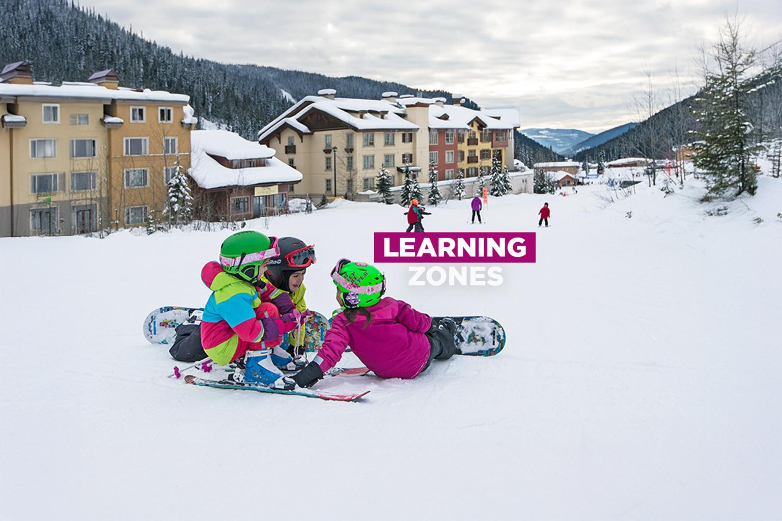 Children sitting on snow with snowboards near buildings, with the words “Learning Zone” overlaid in bold text.