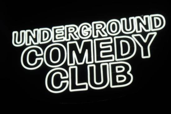 Underground Comedy Club neon sign on black background.