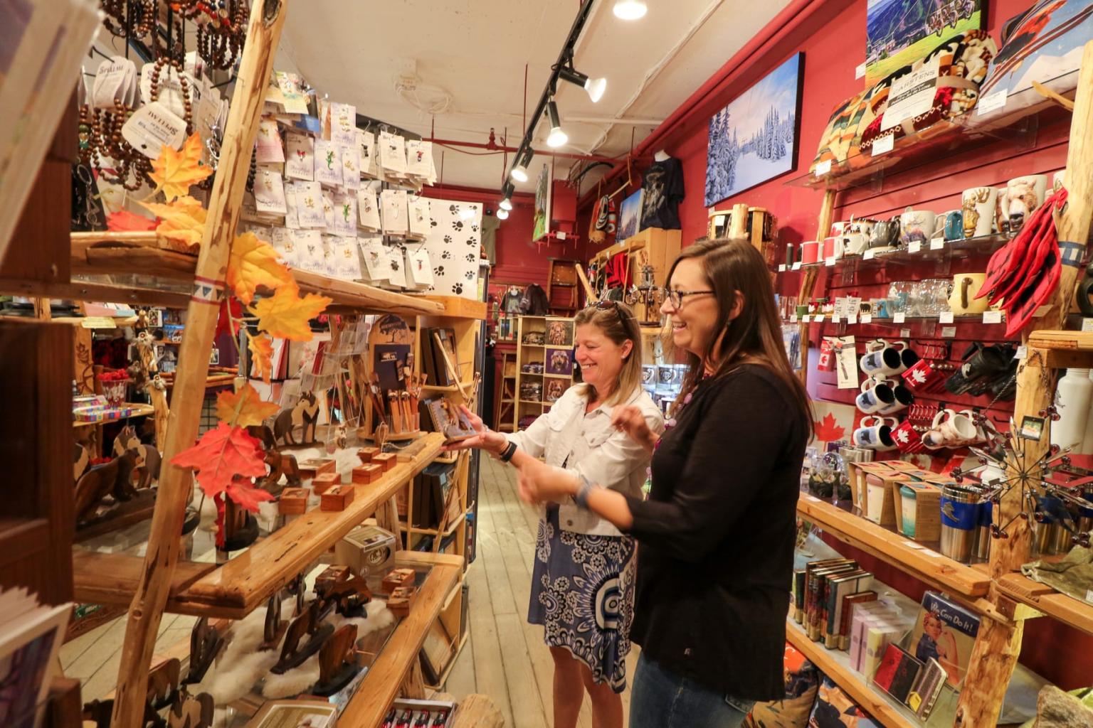 Two women browsing souvenirs in a colorful gift shop.