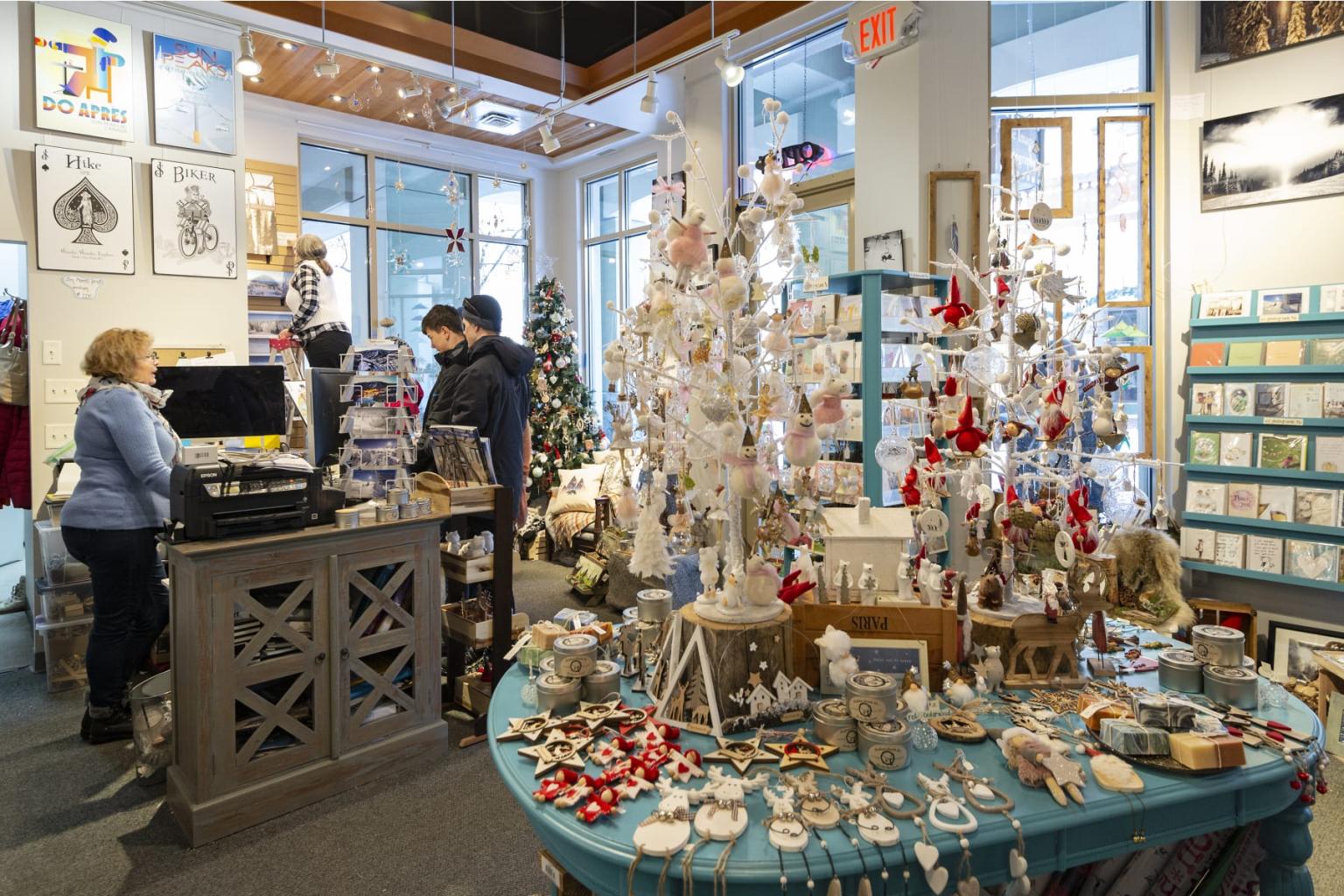 Cozy shop with holiday decorations and customers browsing ornaments.