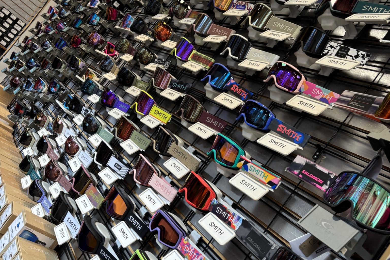 Goggles displayed on a wall rack, featuring various colors and styles.