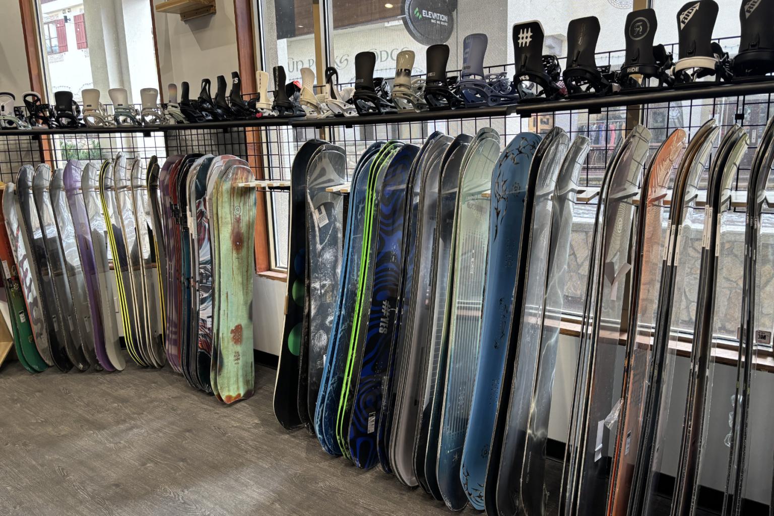 Snowboards lined up in a shop display with various designs.