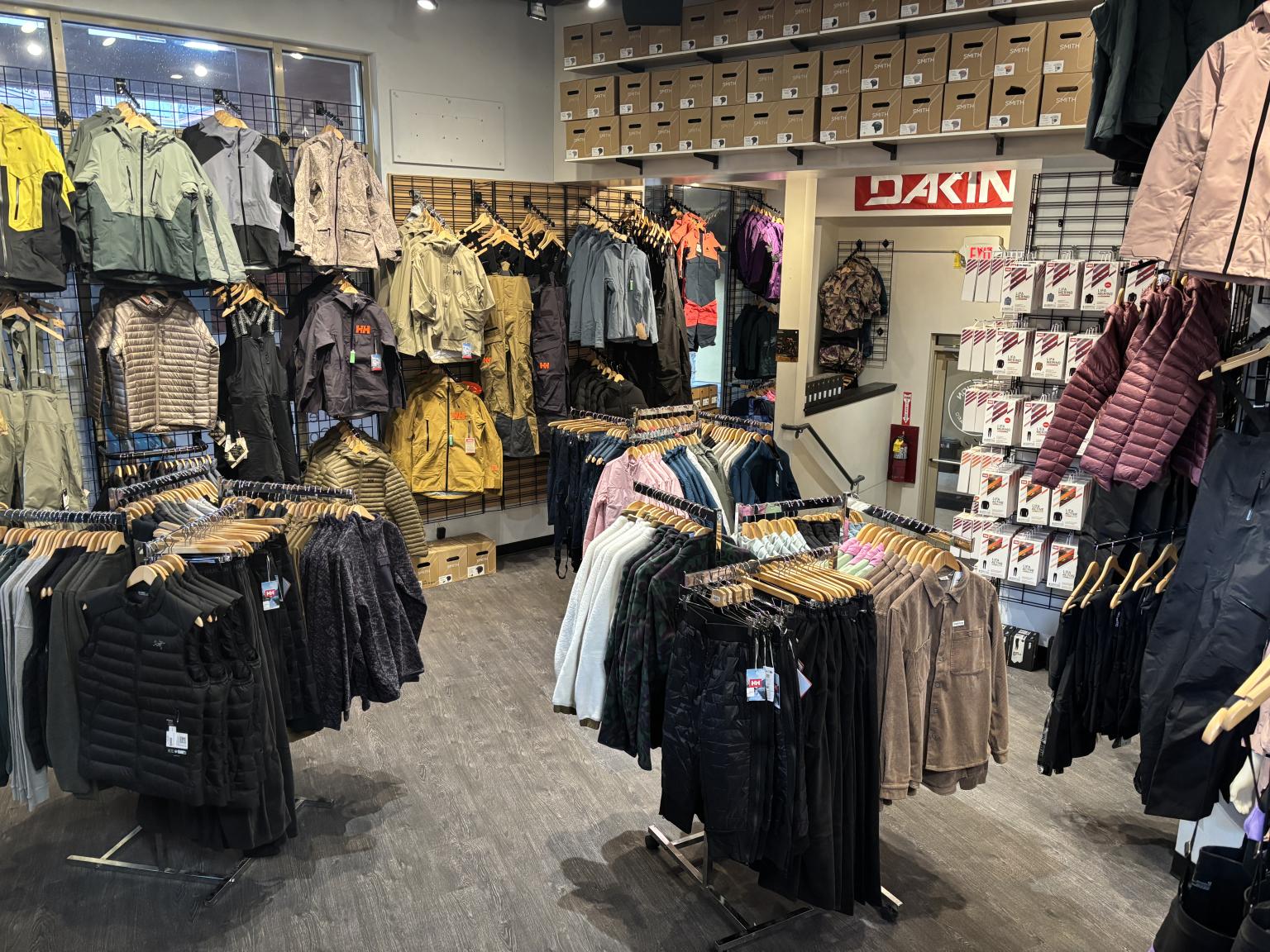 Clothing store with jackets and coats hanging on racks.