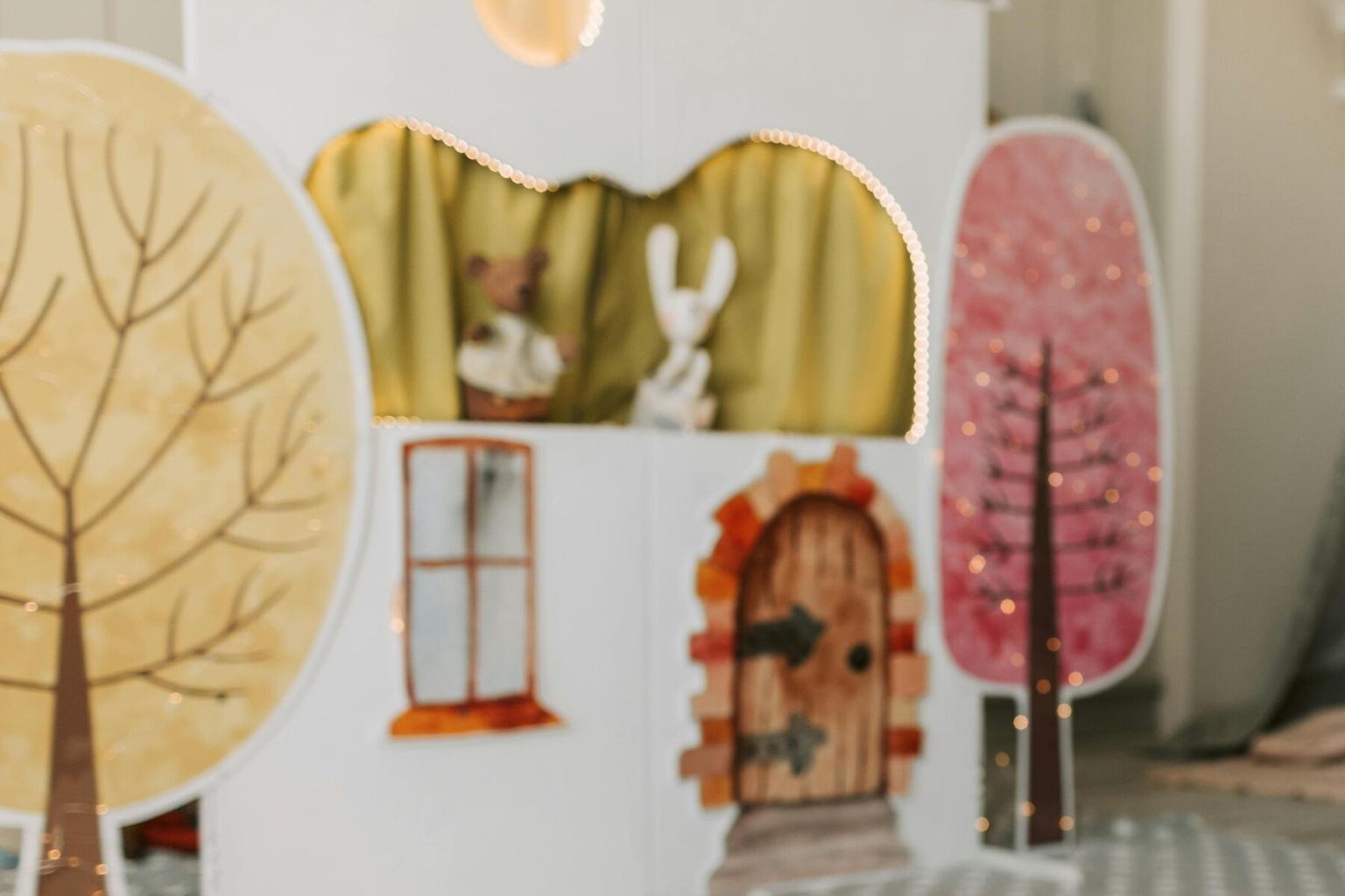 Children's puppet theater with pastel trees and a bunny puppet.