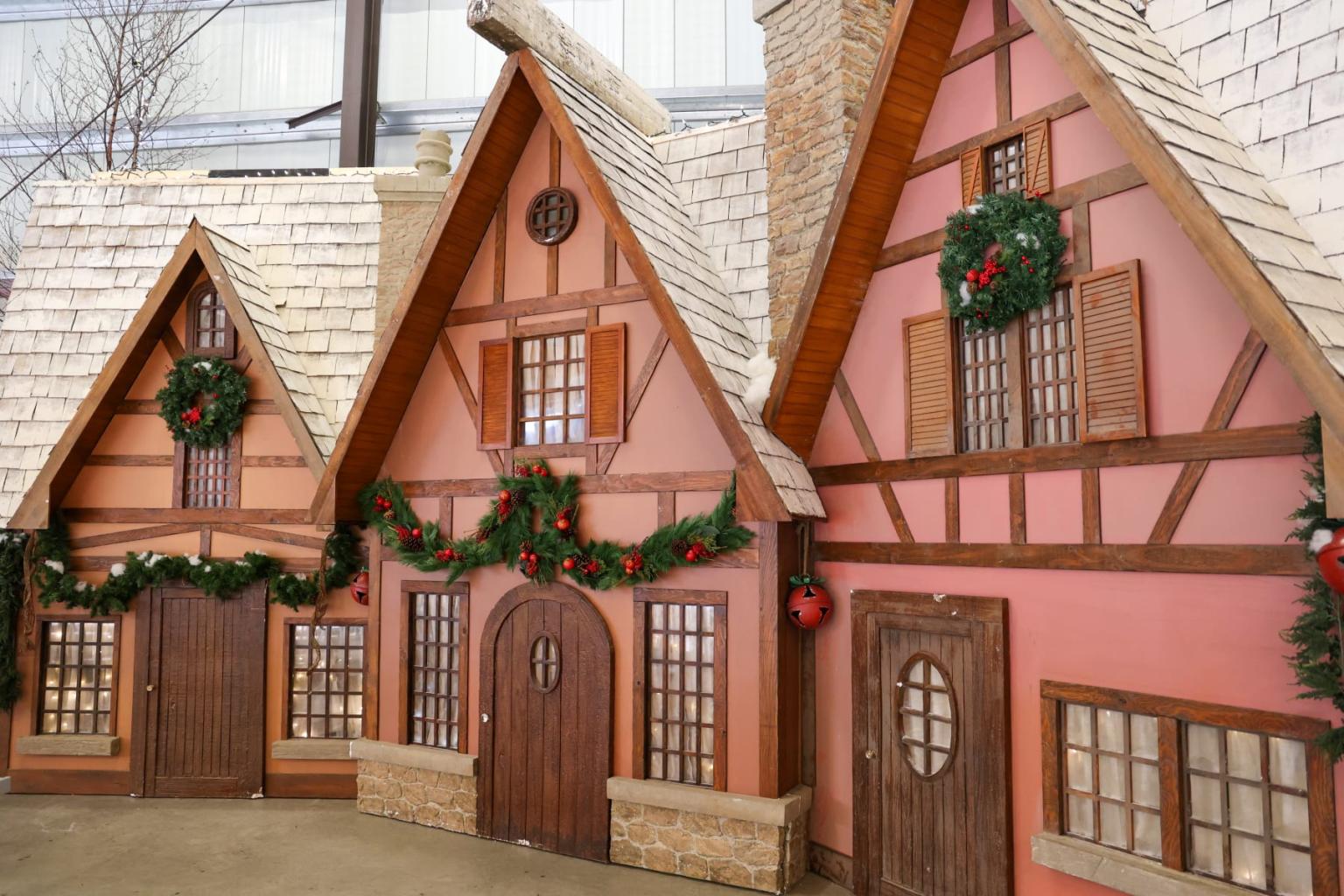 Festive gingerbread-style houses with wreaths and garlands.