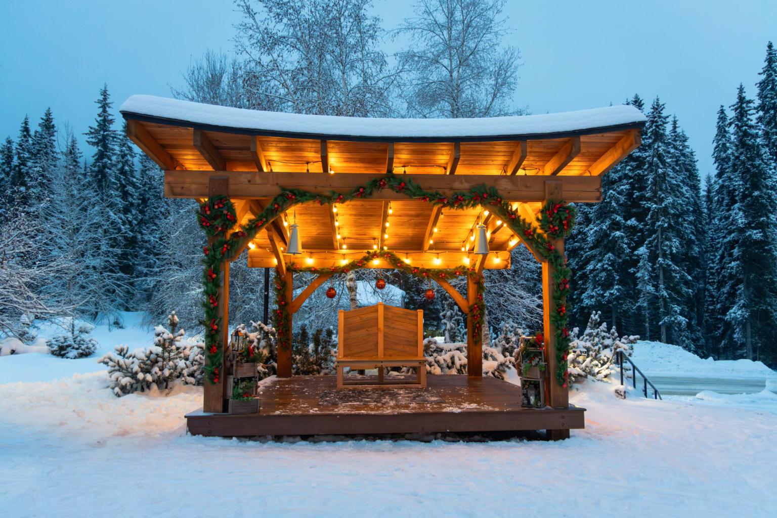 Village stage decorated for Christmas with snow all around.