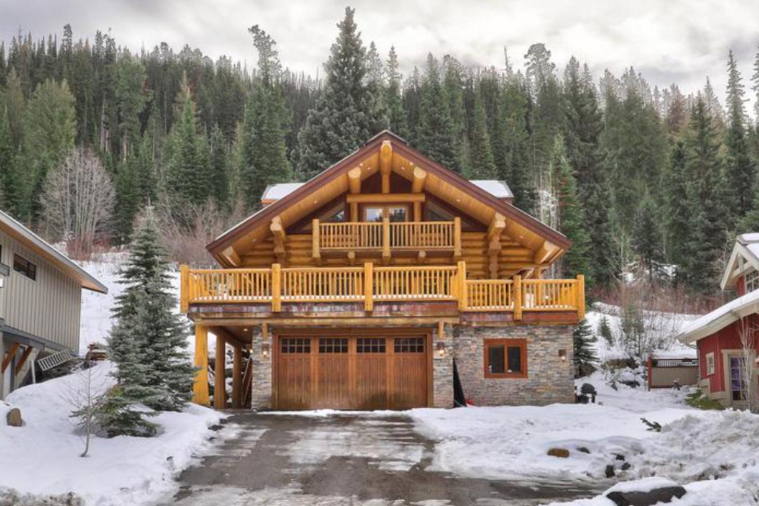 A wooden chalet surrounded by snow and evergreen trees.