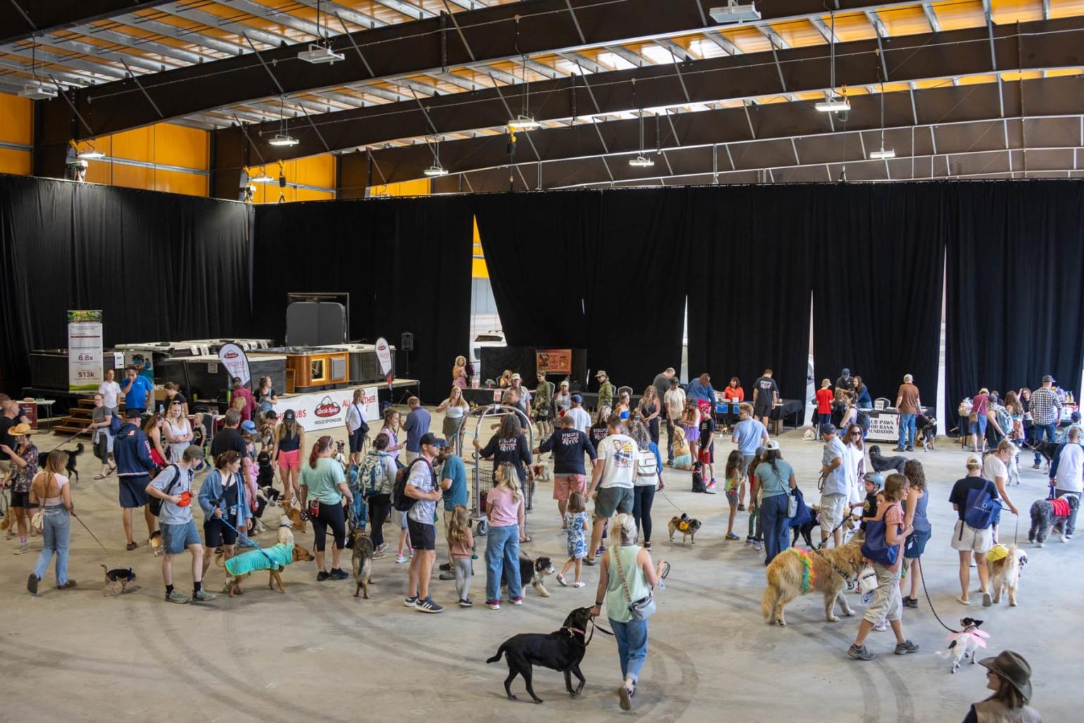 Large indoor dog event with people and various breeds on display.